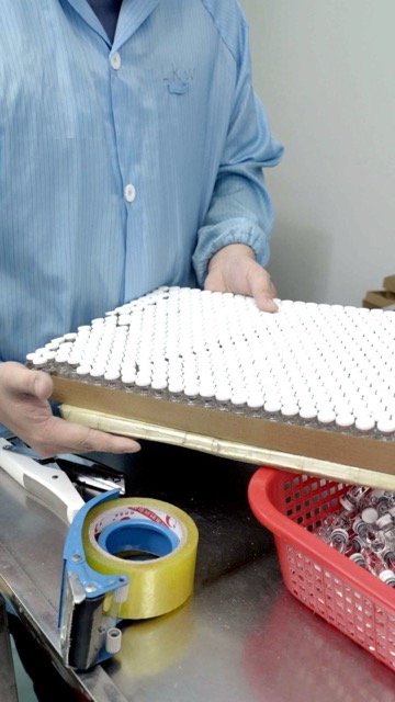 Vials transferred from a drying tray by hand